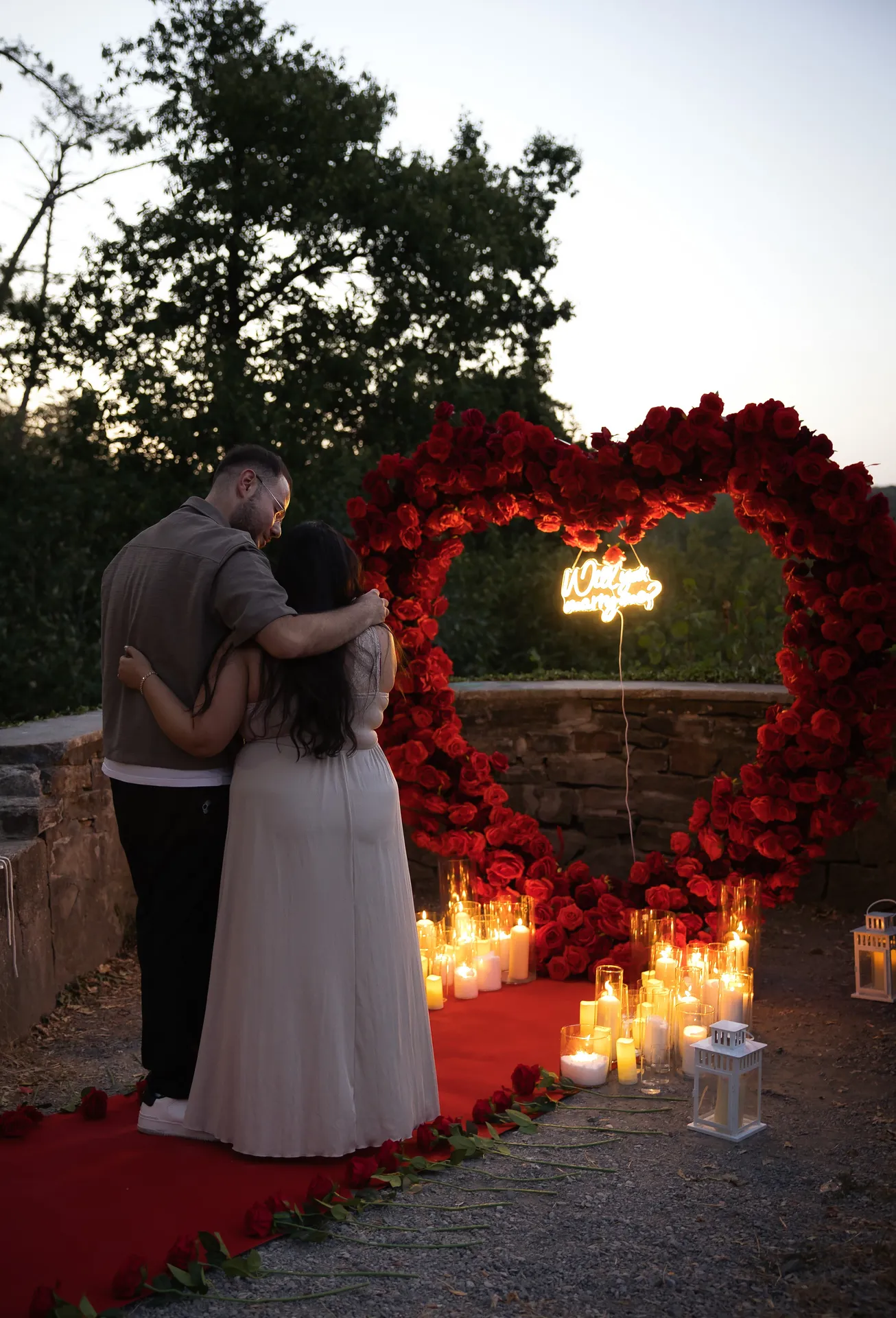 Roter Teppich mit Rosen und Laternen bei der Heiratsantrag-Deko