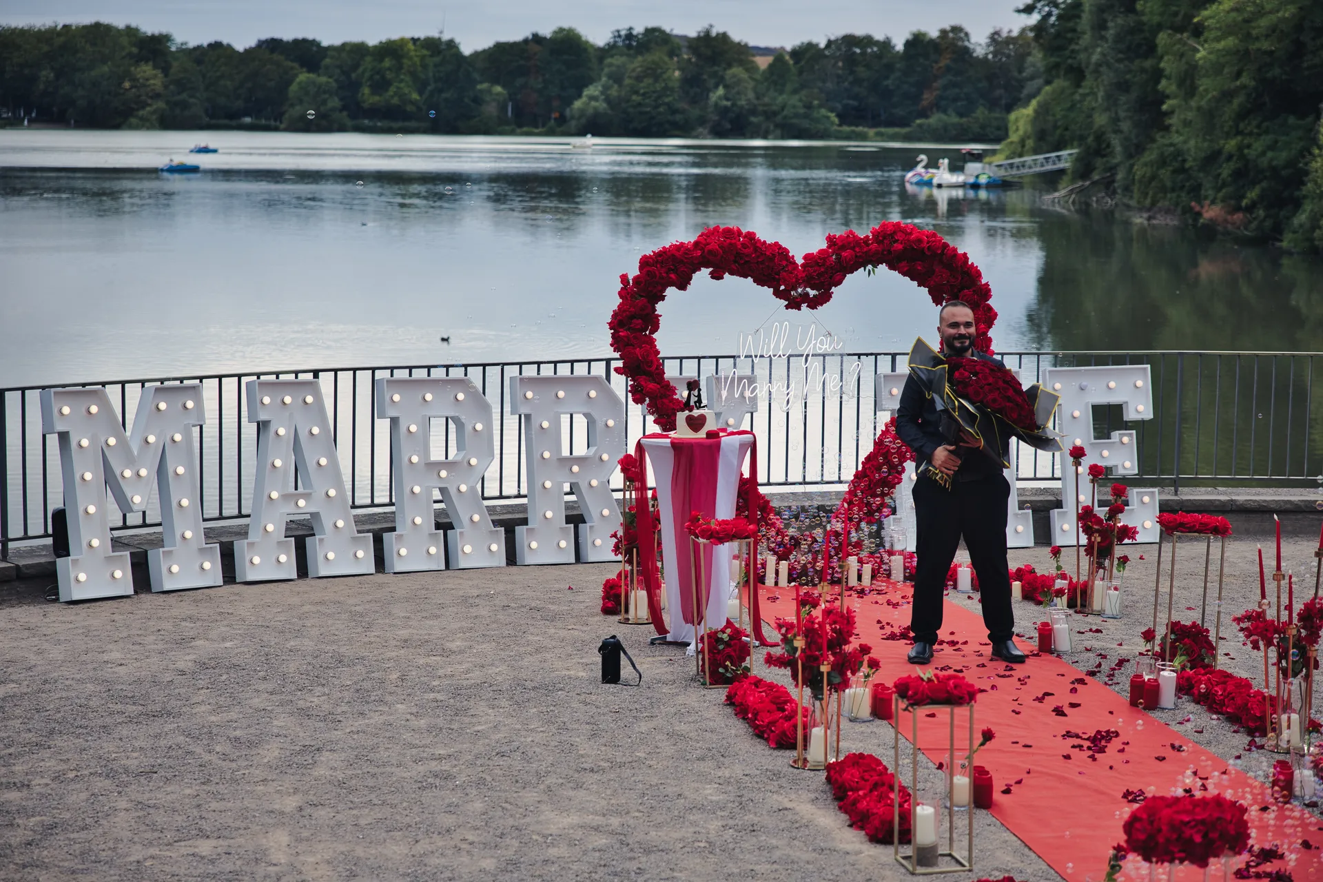 Antragsteller wartet mit Rosenstrauß vor der fertigen Dekoration am Berger See
